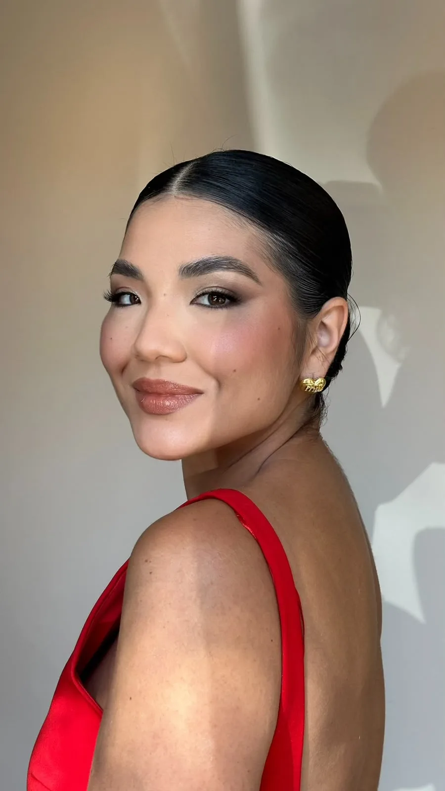 Retrato da Dra. Carolina Utsunomiya sorrindo, de vestido vermelho